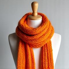 Brightly colored knitted scarf draped on a child-sized mannequin.