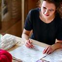 Portrait of Jennifer, a woman sketching knitwear designs in a notebook